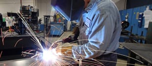 Parts manufacturing in action - Welding a manifold cover in Fabrication