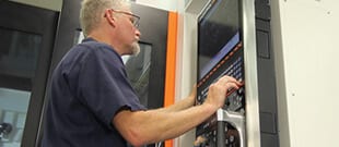 Parts manufacturing in action - entering G-Code commands on a mill machine